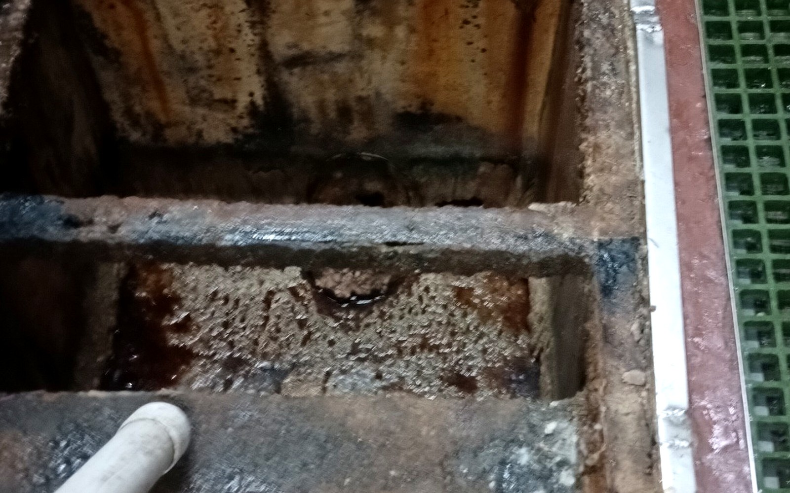 Interior de trampa de grasa durante limpieza y retiro de residuos